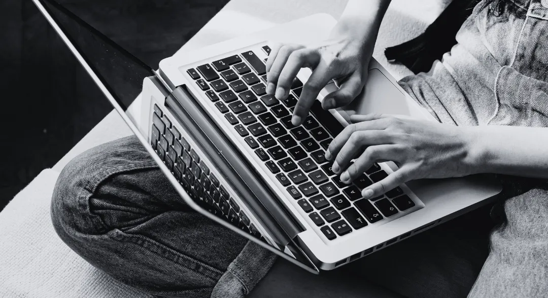 Person tippt auf einem Laptop – Symbolbild zu Hate Speech im Internet